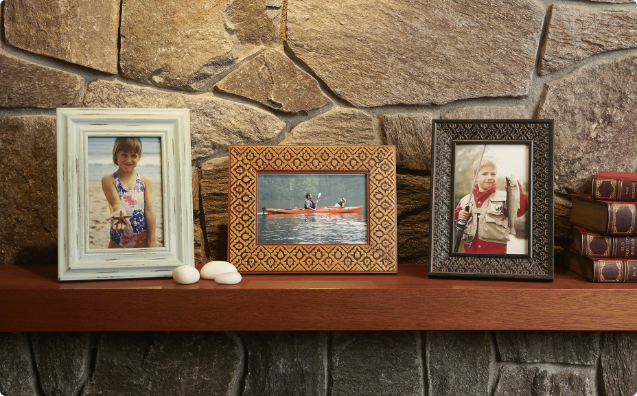 framed pictures on a mantel with black spot blocking view
